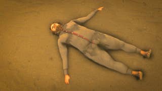 A plump man in a grey onesie lies on the sand.