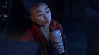 Screenshot of Intergalactic trailer showing woman sipping drink from a straw