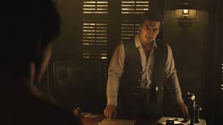 Official Mafia screenshot, cropped, showing a gangster pointing at a document on his desk and looking angry