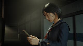 Hinako stands under a light, holding a wooden picture frame in her hands.